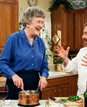 Julia Child cooking with another chef in her home kitchen